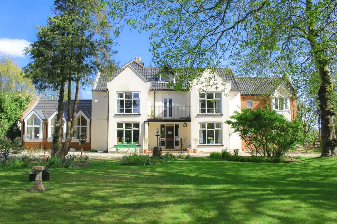 Broadlands Park care home in Upton with lawns and mature trees.